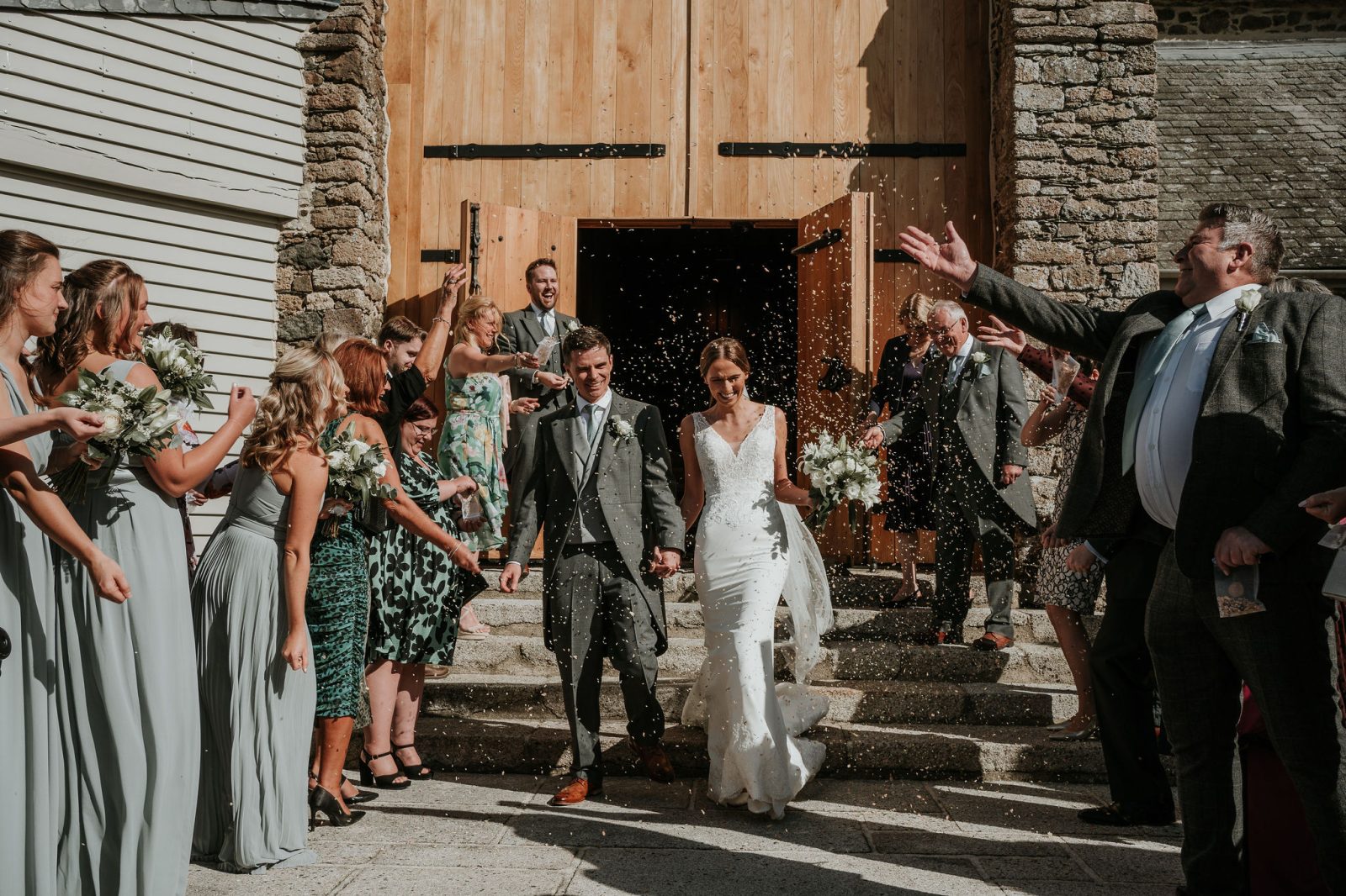 Parsloe_wedding.413 copy couple after wedding on the steps of the great barn devon wedding venue confetti