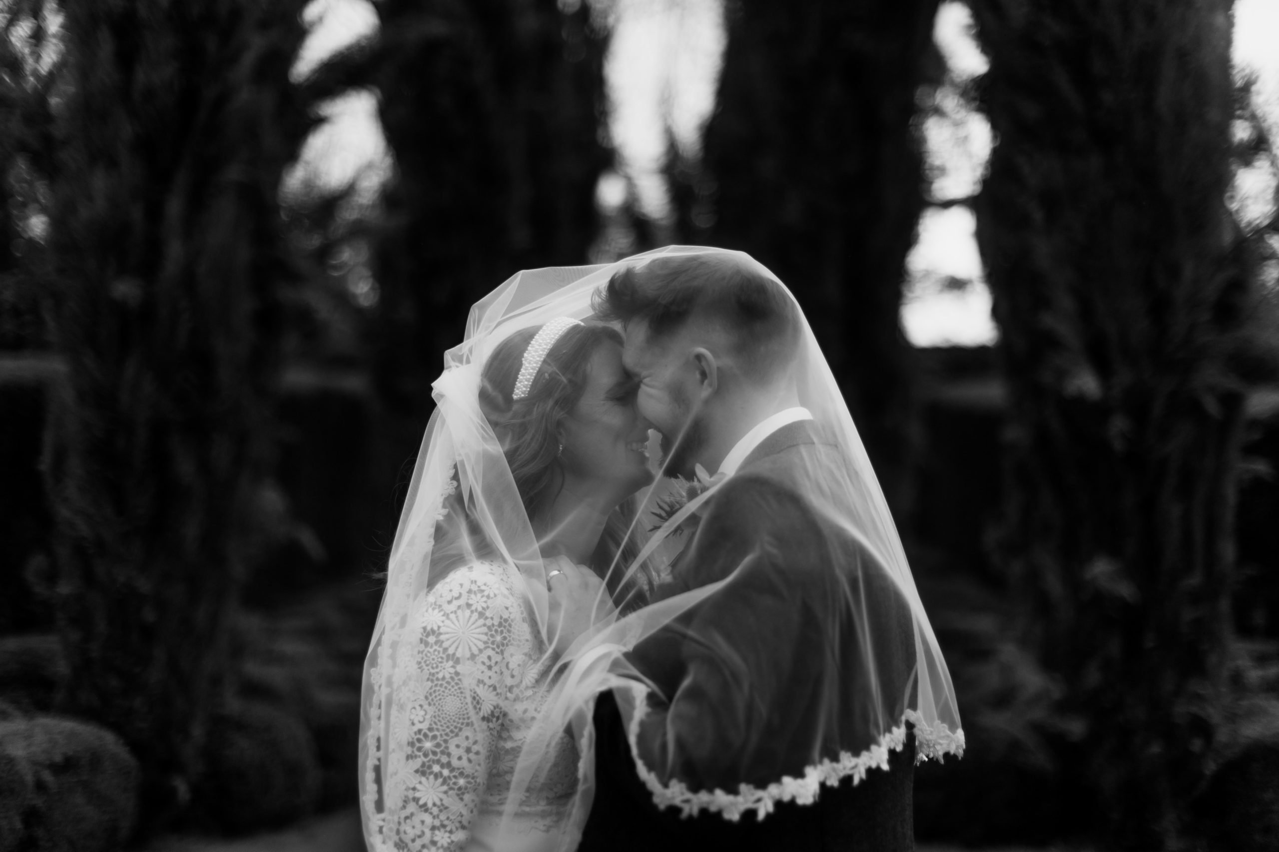 A black and white couple portrait in the gardens at The Great Barn Devon wedding venue