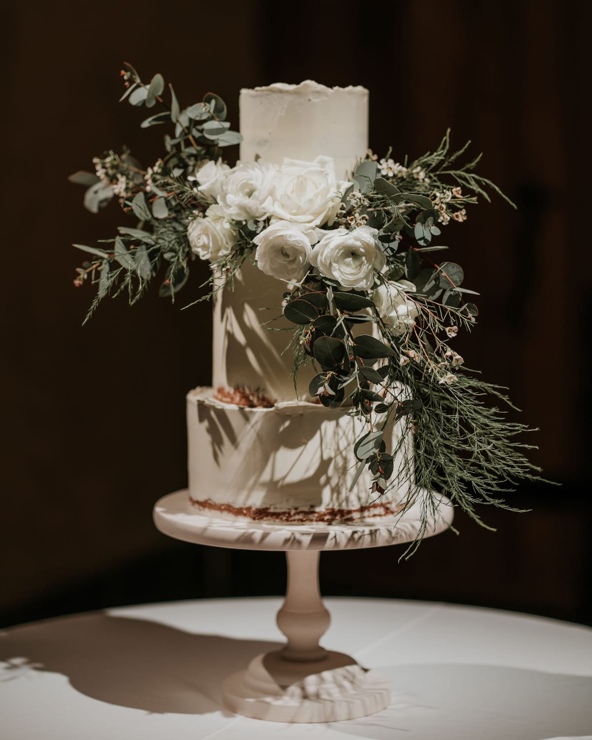 Wedding cake table on display inside The Great Barn Devon, luxury 15th century wedding venue in the countryside near Exeter Devon UK
