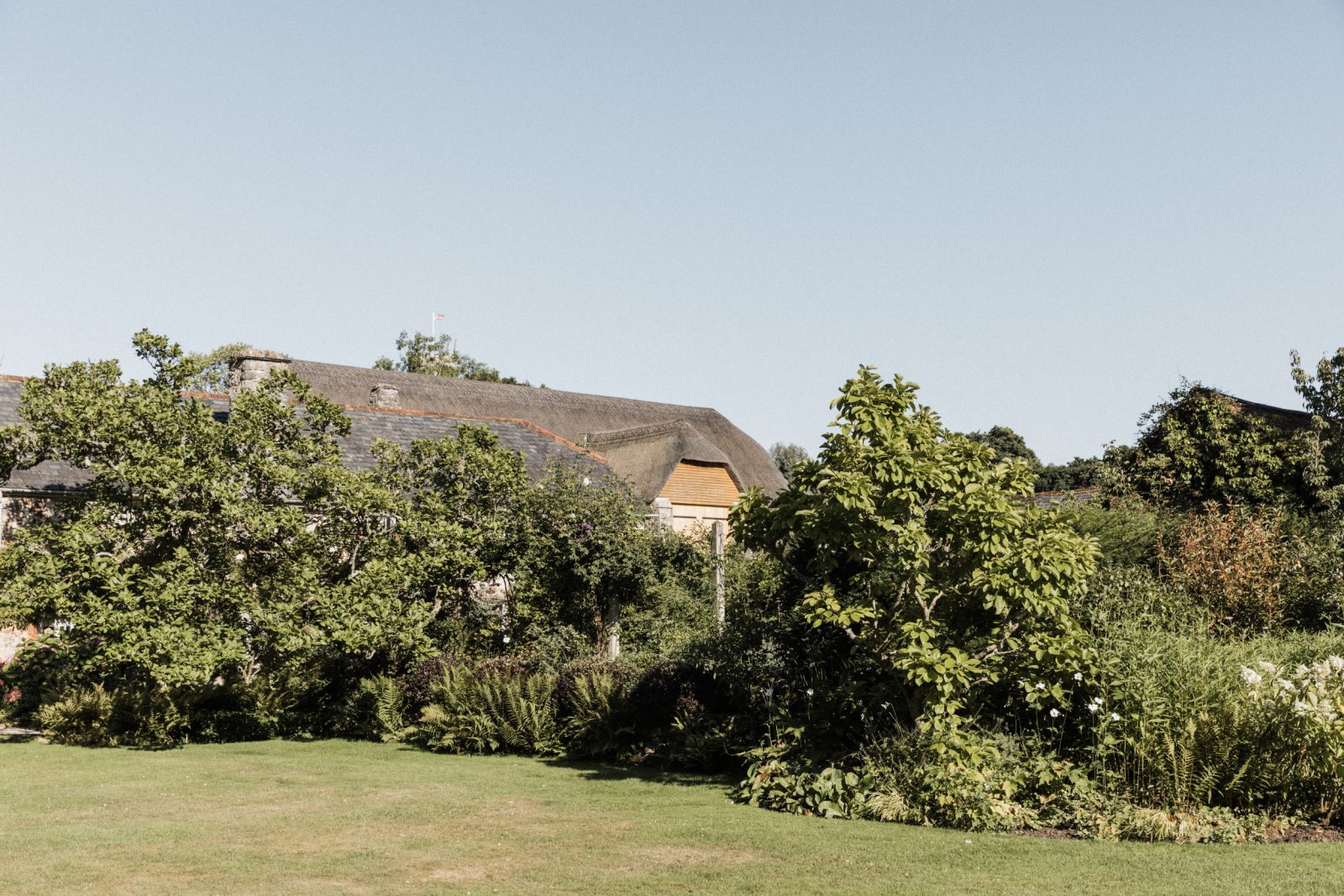 Exterior shot showing grounds and gardens of The Great Barn Devon, a 15th century barn wedding venue | Luxury wedding venue England Devon Wedding Venue |
