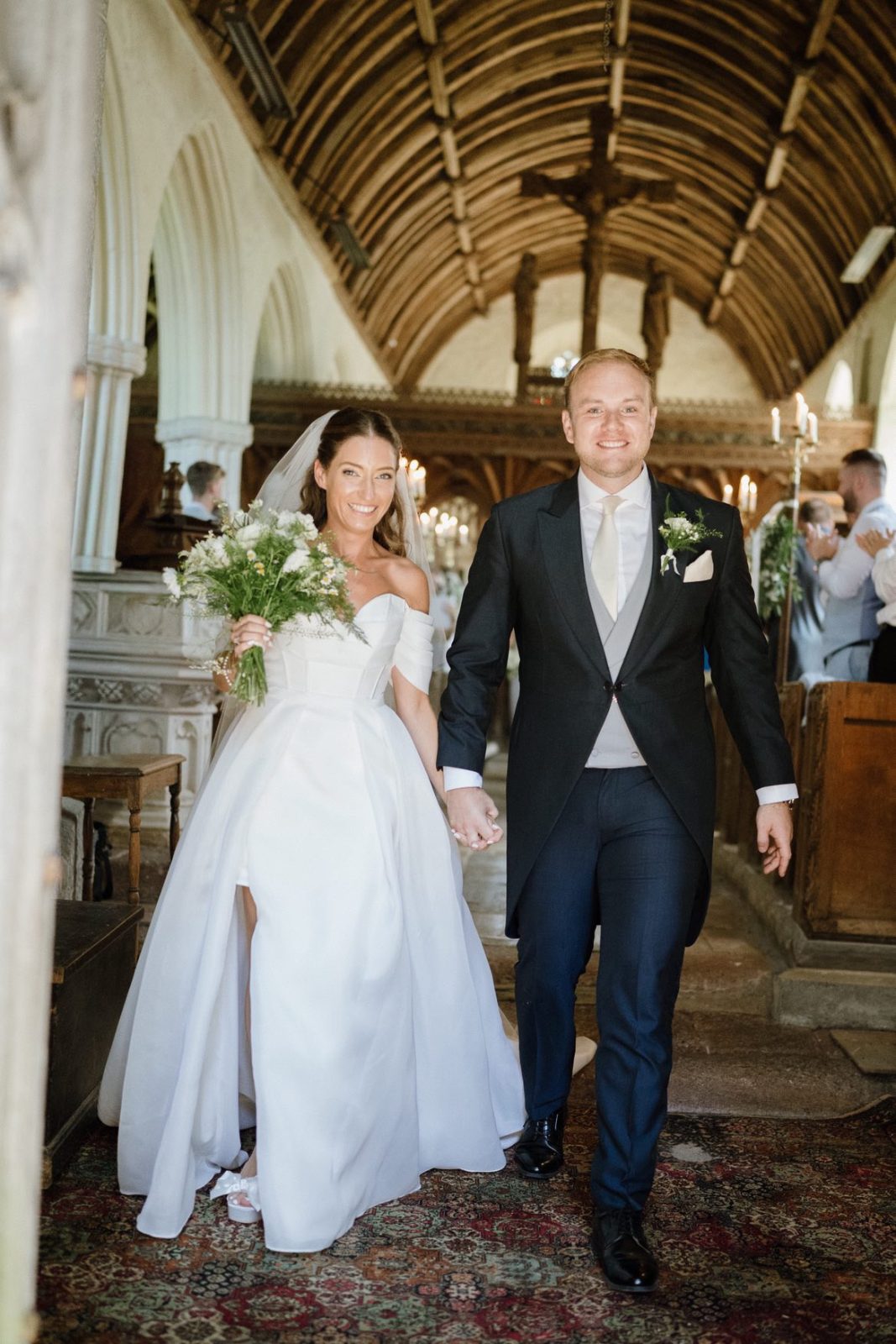 a bride and groom walking down the aisle after their wedding ceremony in the church in Higher Ashton devon