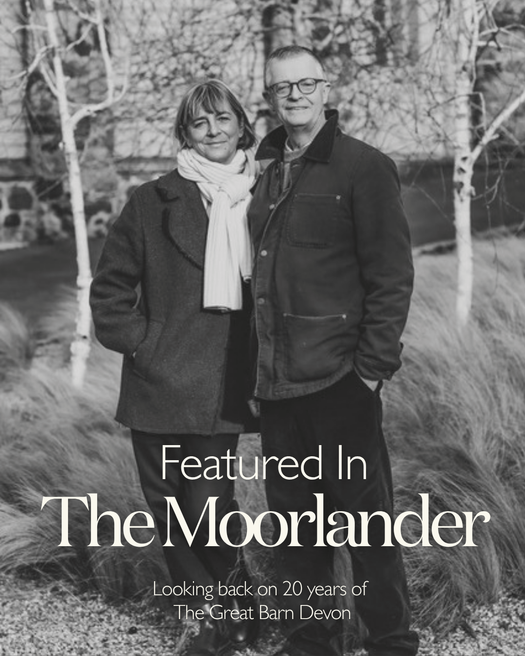 John and Emma Birkin, owners of the great barn devon stood outside the wedding venue alongside words saying "featured in the moorlander - 20 years of the great barn devon"